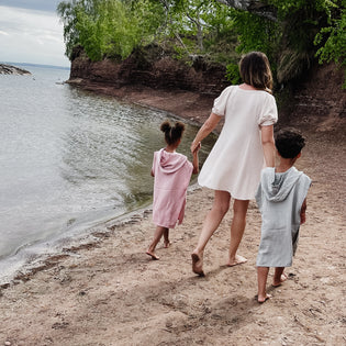  A mom and her 2 kids holding hands walking on the beach